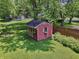 Charming red shed in the backyard with white trim and flower boxes at 9014 Holliday Dr, Indianapolis, IN 46260