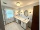Bathroom featuring double sinks, a large mirror, and decorative sconces at 9099 Ne Oak St, Alexandria, IN 46001