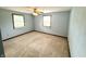 Bedroom features neutral carpet, trim, and two windows for natural light and a ceiling fan at 9099 Ne Oak St, Alexandria, IN 46001