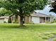 View of a well-maintained brick home showcasing a spacious front yard with mature trees at 9099 Ne Oak St, Alexandria, IN 46001