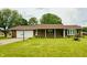 Charming brick home featuring a well-manicured lawn, attached garage, and decorative landscaping at 9099 Ne Oak St, Alexandria, IN 46001