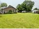 Brick home with a well-manicured lawn and mature trees offering great outdoor space at 9099 Ne Oak St, Alexandria, IN 46001
