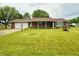 Charming brick home featuring a well-manicured lawn, attached garage, and decorative landscaping at 9099 Ne Oak St, Alexandria, IN 46001
