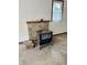 A wood-burning stove sits beside a small brick fireplace in the garage at 9099 Ne Oak St, Alexandria, IN 46001