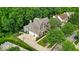 Aerial view of a brick home with a spacious driveway, basketball hoop, and lush green surroundings at 9834 Belcrest Ln, Indianapolis, IN 46256
