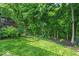Well-manicured backyard with lush green grass and plenty of trees at 9834 Belcrest Ln, Indianapolis, IN 46256