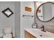 Modern bathroom with wood accent wall, stylish round mirror and modern fixtures at 9834 Belcrest Ln, Indianapolis, IN 46256