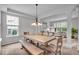 Open-concept dining area features a rustic wood table and a stylish chandelier, perfect for entertaining at 9834 Belcrest Ln, Indianapolis, IN 46256