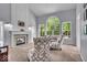 Spacious living room featuring a fireplace, large windows, and comfortable seating at 9834 Belcrest Ln, Indianapolis, IN 46256
