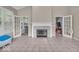 Bright living room features a fireplace, tile flooring, and french doors leading to a sunroom at 9834 Belcrest Ln, Indianapolis, IN 46256
