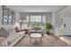 Neutral living room featuring a sofa, rounded side table, an area rug, and natural light at 9834 Belcrest Ln, Indianapolis, IN 46256