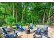 Outdoor patio with blue Adirondack chairs surrounding a fire pit and beautiful mature trees at 9834 Belcrest Ln, Indianapolis, IN 46256