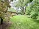 Brick home with a lush, expansive backyard featuring mature trees and a shed at 10130 Central Ave, Carmel, IN 46280