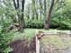 Brick patio area with a white fence adjoins a wooded backyard with shed at 10130 Central Ave, Carmel, IN 46280