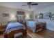 Bedroom with two beds, wood floors, ceiling fan, and charming decor, creating a comfortable and inviting space at 10130 Central Ave, Carmel, IN 46280
