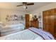 Bedroom with two beds, a ceiling fan, wooden floors, and ample storage space, perfect for guests at 10130 Central Ave, Carmel, IN 46280