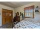Comfortable bedroom with a floral quilt, dresser, and natural light from a window with white shutters at 10130 Central Ave, Carmel, IN 46280