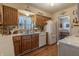 Traditional kitchen boasts wooden cabinets, double sink, white appliances, and access to dining area at 10130 Central Ave, Carmel, IN 46280