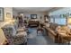 Spacious living room featuring a piano, rocking chair, and a plush sofa, providing a cozy and inviting atmosphere at 10130 Central Ave, Carmel, IN 46280
