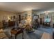 Open living room with vintage furniture and decor, a floral armchair, and a piano, showcasing a classic design at 10130 Central Ave, Carmel, IN 46280