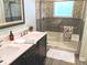 Bathroom featuring a double vanity with dark wood cabinets, framed mirror, and modern fixtures at 10421 Sand Creek Blvd, Fishers, IN 46037