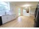 Sunlit kitchen with stainless appliances, white cabinets, a garden view and hardwood floors at 10501 Morning Song Dr, Fishers, IN 46038