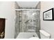 Modern bathroom features a glass-enclosed shower with safety bars and stylish vertical faux wood-grain panels at 10519 Hyacinth Ct, Noblesville, IN 46060