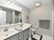 A bright bathroom with a double sink vanity, large mirror, and tile flooring at 10519 Hyacinth Ct, Noblesville, IN 46060