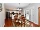 Bright dining area adjacent to kitchen with wood table, four chairs, and stylish chandelier lighting at 10519 Hyacinth Ct, Noblesville, IN 46060