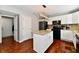 Kitchen with white cabinets, an island with granite countertops, and black appliances provides a functional space at 10519 Hyacinth Ct, Noblesville, IN 46060