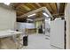 Unfinished basement with exposed ceiling and concrete walls, workbench, water filtration, and stainless refrigerator at 11036 Ravenna Way, Indianapolis, IN 46236