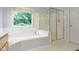 Bright bathroom featuring a shower, soaking tub, and window at 11036 Ravenna Way, Indianapolis, IN 46236