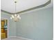 Elegant dining area with a chandelier and view into the kitchen showcases sophisticated interior design at 11036 Ravenna Way, Indianapolis, IN 46236