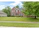 Classic brick home with manicured lawn, dark shutters, and lush green trees creating inviting curb appeal at 11036 Ravenna Way, Indianapolis, IN 46236