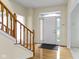 Bright foyer with hardwood floors and a wooden staircase leading upstairs creates a welcoming entrance at 11036 Ravenna Way, Indianapolis, IN 46236