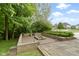 Stone patio area with a built in fireplace or barbecue surrounded by manicured bushes and trees at 11036 Ravenna Way, Indianapolis, IN 46236