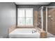 The neutral colored bathroom offers a tiled-in tub with a large window to view the backyard at 1237 Wolcott Ct, Westfield, IN 46074