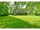 Spacious backyard with lush greenery and a home featuring a large deck at 12380 Creekwood Ln, Carmel, IN 46032