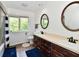 Well-lit bathroom featuring double sinks and bright window with view of trees at 12380 Creekwood Ln, Carmel, IN 46032