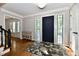 Bright foyer with a dark blue front door, hardwood floors, and beautiful rug at 12380 Creekwood Ln, Carmel, IN 46032