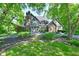 Stunning stone-and-brick home with lush landscaping, mature trees, and circular driveway at 12380 Creekwood Ln, Carmel, IN 46032