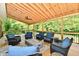 Relaxing covered deck with comfortable seating, fire pit, and scenic wooded views at 12380 Creekwood Ln, Carmel, IN 46032
