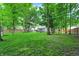 Expansive backyard featuring lush green grass, mature trees providing shade, and a charming pergola for relaxing outdoor entertainment at 1264 Black Oak Dr, Greenwood, IN 46143