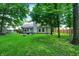 Lush backyard features a well-maintained lawn, mature trees offering shade, a charming pergola, and a fenced boundary for privacy at 1264 Black Oak Dr, Greenwood, IN 46143