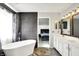 Well-lit bathroom with white cabinets, a large soaking tub, and a view into the connected bedroom at 1264 Black Oak Dr, Greenwood, IN 46143