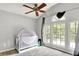 Bright bedroom features three windows overlooking water, gray walls, a ceiling fan, and a baby bed at 1264 Black Oak Dr, Greenwood, IN 46143
