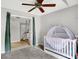 Bedroom view shows a crib, ceiling fan, gray walls and an entrance to another room with stairs at 1264 Black Oak Dr, Greenwood, IN 46143