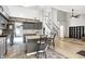 Kitchen island with sink and barstool seating area, leading to the living area and staircase at 1264 Black Oak Dr, Greenwood, IN 46143