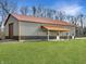 Large barn on a well-manicured lawn offers ample space and features a covered porch and two large doors at 1412 10Th St, Danville, IN 46122