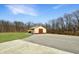 Modern barn with a red roof and big bay door surrounded by a concrete driveway and green grass at 1412 10Th St, Danville, IN 46122